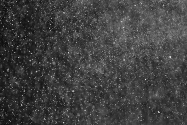 soyut arkaplan, siyah üzerine beyaz bokeh düşen kar sisi görünümünü örtüyor