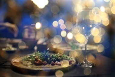 Lokantada bir akşam, bulanık bir arka plan, bokeh, alkol konsepti, bir barda şarap kadehi.