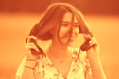 Yazın genç esmer, tarlada uzun saçlı, gün batımında poz veren mutlu insan sağlığı güzeli.