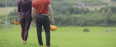 Kasklı aşk çifti doğa, halatla tırmanma parkı, gökyüzüne karşı.