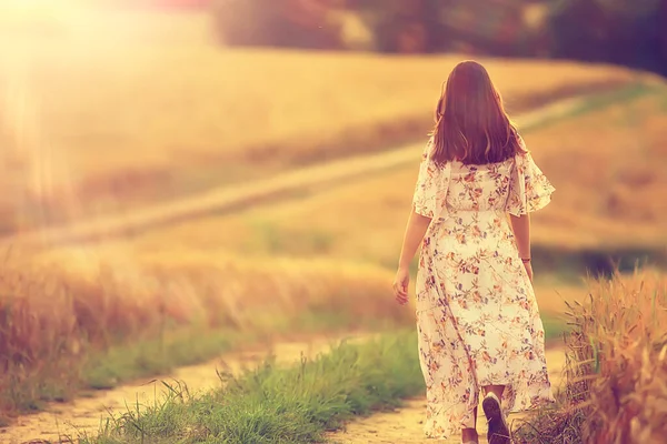 女性は夏に小麦畑を歩き顔も葉もない背中からの眺め — ストック写真