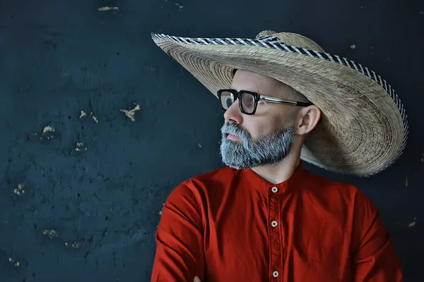 hipster guy in glasses with a gray beard in a hat with brim. emotionally posing model man