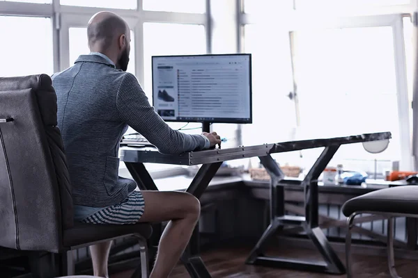 man without pants in working on a computer, laptop, humor coronavirus remote work in underpants