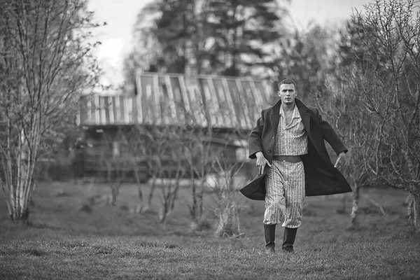 ヴィンテージ男若い村黒と白 東ヨーロッパスタイル レトロなコートとブーツ — ストック写真