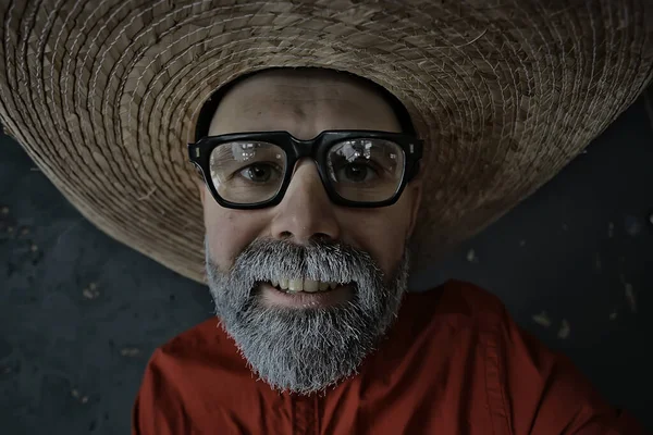 hipster guy in glasses with a gray beard in a hat with brim. emotionally posing model man