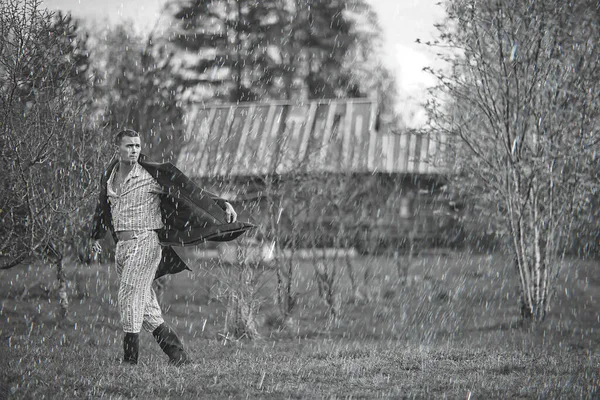 ヴィンテージ男若い村黒と白 東ヨーロッパスタイル レトロなコートとブーツ — ストック写真
