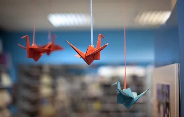 Origami birds hanging on ropes
