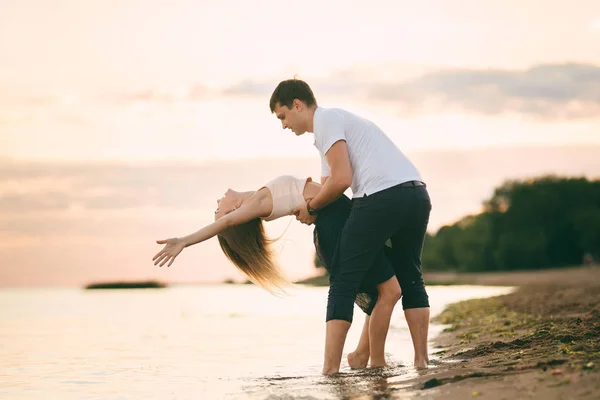 Młoda szczęśliwa para całować na seashore — Zdjęcie stockowe