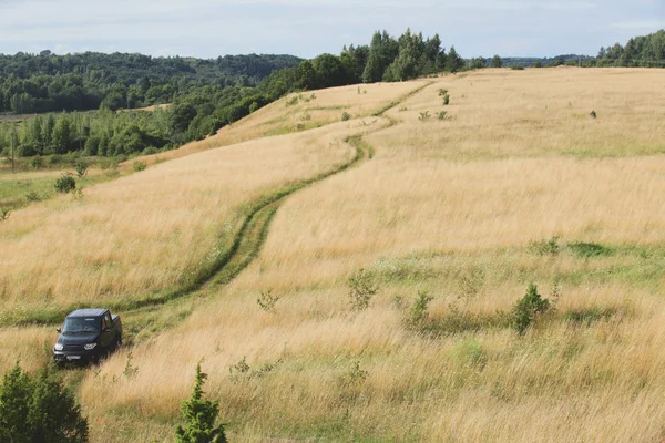 Voiture garée dans un champ sur une route de campagne — Photo