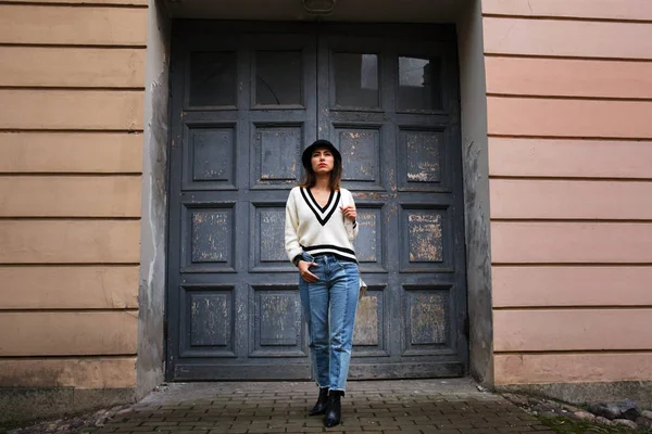 Outdoor full body portrait of young beautiful fashion girl posing on street. Model looking aside. Lady wearing stylish winter clothes. Female fashion.