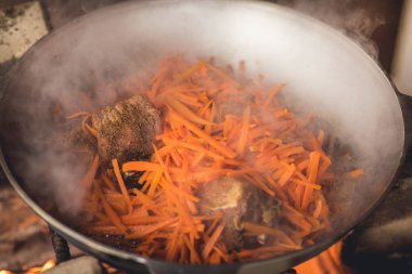 Kazan içinde Plov yemek. Sadece et, soğan ve havuç kazanı içinde. Alan mutfak.