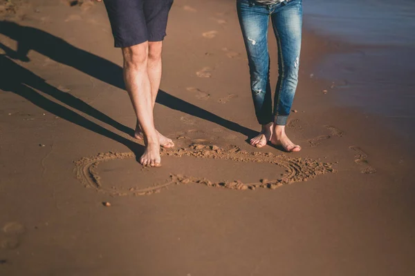 Cultivo casal posando na areia molhada — Fotografia de Stock