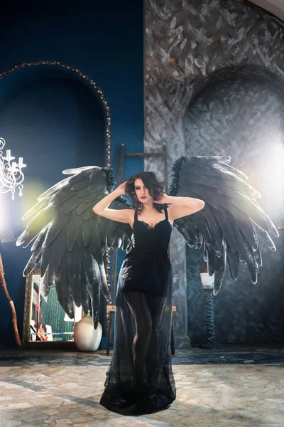 Чуттєва жінка в чорному костюмі ангела — стокове фото