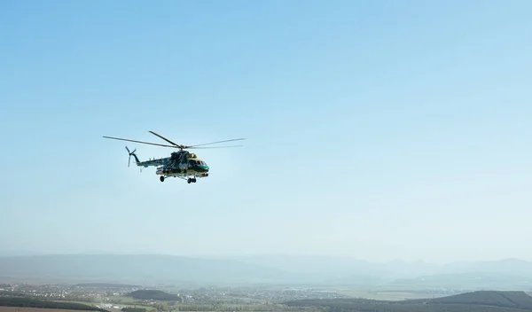 Een militaire helikopter vliegen over het dorp — Stockfoto