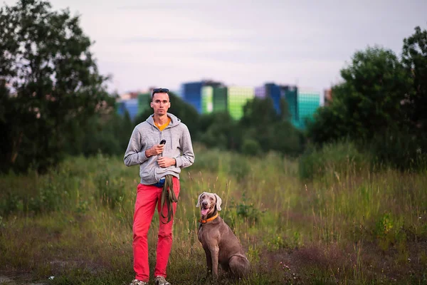 Hombre parado en tierra con perro en el campo — Foto de Stock