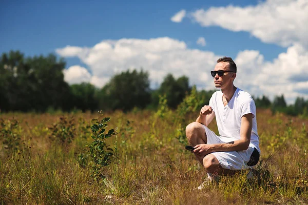 Man sitting in rural field in summer day — Stock Photo, Image