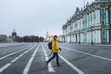 Sarı ceketli genç adam yolda yürüyordu. Şehrin merkezindeki boş dvortsovaya meydanı