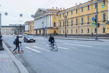 Saint-petersburg, Rusya - 31 Mart 2020: Kendini izole etmenin birinci gününde şehrin merkezinde boş sokaklar. Bir adam yaya geçidinde bisiklete biniyor.