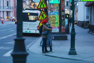 Saint-petersburg, Rusya - 31 Mart 2020: yaya geçidinde maskeli adam ve kadın kucaklaşıyor. Boş bir akşam kenti, alacakaranlıkta kendini izole etmenin ilk gününde..