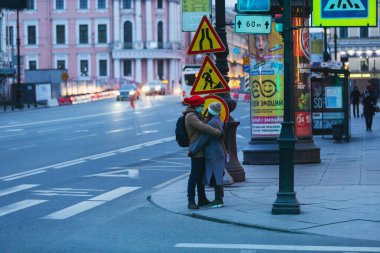 Saint-petersburg, Rusya - 31 Mart 2020: yaya geçidinde maskeli adam ve kadın kucaklaşıyor. Boş bir akşam kenti, alacakaranlıkta kendini izole etmenin ilk gününde..