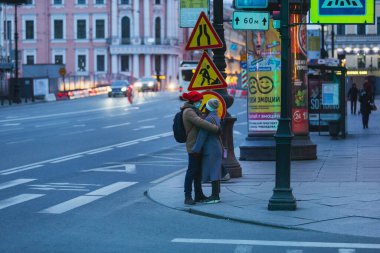 Saint-petersburg, Rusya - 31 Mart 2020: yaya geçidinde maskeli adam ve kadın kucaklaşıyor. Boş bir akşam kenti, alacakaranlıkta kendini izole etmenin ilk gününde..