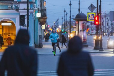 Saint-petersburg, Rusya - 31 Mart 2020: COVID-19 salgını. Akşam kentinde koşan bir adam. Sosyal uzaklık.