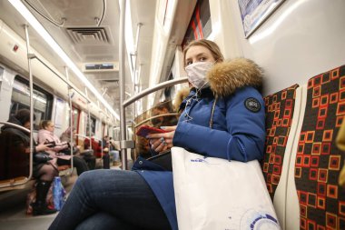 Saint-petersburg, Rusya - 04 Nisan 2020: metroda maskeli genç bir kadının portresi. Yeni Coronavirus COVID-19. Salgın veya salgın sırasında sağlık hizmeti kavramı