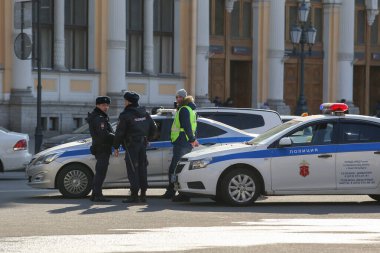Saint-petersburg, Rusya - 7 Nisan 2020: Nevsky Prospekt, Vosstaniya Meydanı. Bir polis arabası ve birkaç üniformalı polis yolda dikilip konuşuyor.