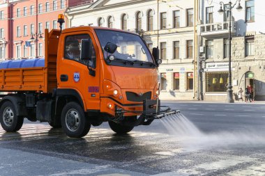 Saint-petersburg, Rusya - 7 Nisan 2020: Sokakları temizlemek için turuncu süpürge, Nevsky Prospekt kaldırımını sulamak