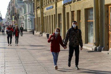 Saint-petersburg, Rusya - 7 Nisan 2020: Nevsky Prospekt. Kaldırımda yürüyen maskeli genç bir çift. İnsanlar evde kalmak istemiyor.