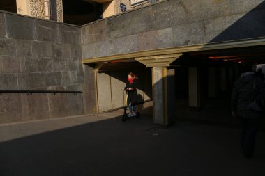 Saint-petersburg, Rusya - 7 Nisan 2020: Nevsky Prospekt. Elektrikli scooterlı bir kız, güneşli bir günde yaya geçidinden çıkıyor. Koronavirüsten dolayı kendini izole eden şehir.