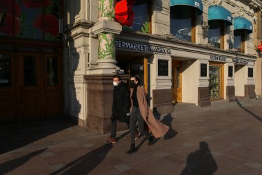 Saint-petersburg, Rusya - 7 Nisan 2020: Nevsky Prospekt. Kaldırımda yürüyen maskeli genç bir çift. Şehirdeki izolasyon rejimine rağmen insanlar evlerinde kalmak istemiyorlar.