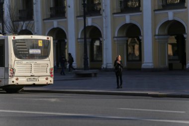 Saint-Petersburg, Rusya - 7 Nisan 2020: genç bir kız otobüs durağında duruyor. Şehrin koronavirüs yüzünden kendini izole etme rejimi var.