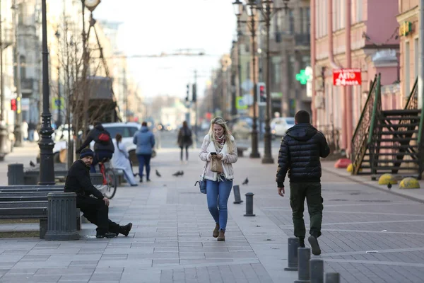 ロシアのサンクトペテルブルク 2020年4月8日 ソビエト初の通りの側面図 若い女性が通りを歩いて電話を見ている 失業者は隔離されたくない家に座って — ストック写真