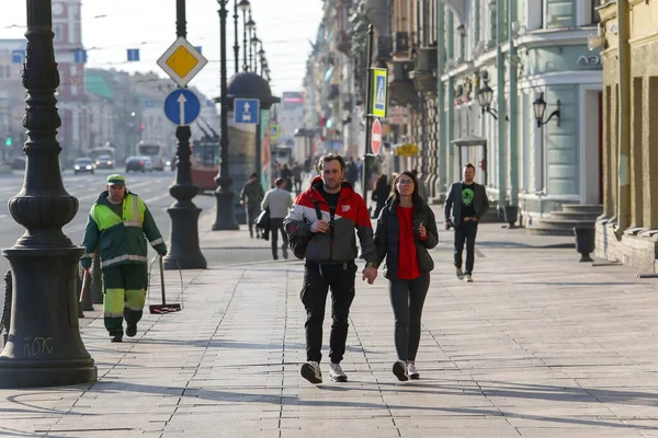 Saint-petersburg, Rusya - 7 Nisan 2020: Nevsky Prospekt. Kaldırımda yürüyen genç bir çift. İnsanlar evde kalmak istemiyor.