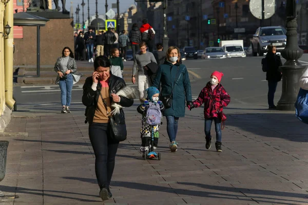 ロシア サンクトペテルブルク 2020年4月7日 ネフスキー プロペクトの歩道を歩くマスクの子供を持つ若い女性 人々はCovid 19のために家に滞在したくない — ストック写真