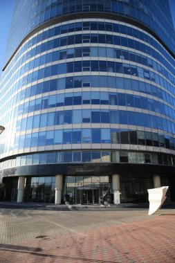 Güneşli bir günde cam kapılı modern iş merkezi cephesi
