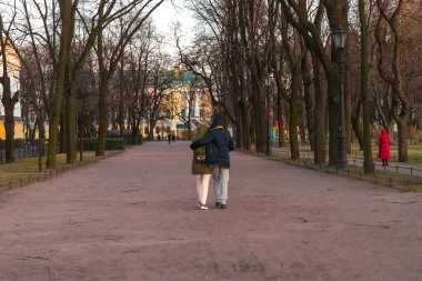 Tanımlanamayan bir çiftin parkta kucak kucağa yürümesi.