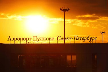 Pulkovo Uluslararası Havalimanı - gün batımında dış bina. Uluslararası uçuşlar koronavirüs salgını nedeniyle iptal edildi. Tabeladaki yazı: Pulkovo havaalanı Saint Petersburg