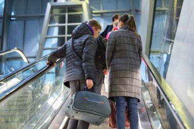 Saint-Petersburg, Rusya, 30 Nisan 2020: Pulkovo Uluslararası Havalimanı 'nın iç kısımlarında yürüyen merdivenlerden çıkan insanların arka görünümü.