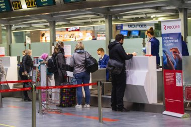Saint-Petersburg, Rusya, 30 Nisan 2020: Pulkovo Uluslararası Havaalanı 'nda kayıt masası. Maskeli personel yolcuları kontrol etsin. Coronavirüs nedeniyle uluslararası uçuşlar iptal edildi