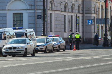Saint-Petersburg, Rusya - Mayıs 12020: Trafik polisi şehir merkezindeki trafiği kontrol ediyor. Yol boyunca birkaç polis arabası park halinde. Zafer gününden önce güçlenmek