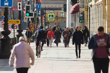 Saint-Petersburg, Rusya - Mayıs 12020: İnsanlar güneşli bir günde Nevsky Prospekt boyunca yürürler. Şehirde kendi kendini izole eden bir rejim var. Bazı yayalar maske takıyor.