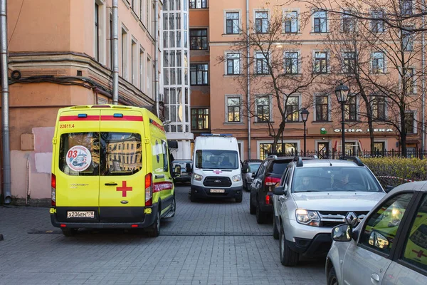 Saint-Petersburg, Rusya - Mayıs 12020: Sarı ve beyaz ambulanslar avluda karşı karşıya duruyorlar. Şehrin, koronavirüs salgınıyla bağlantılı bir kendini izole etme rejimi var.