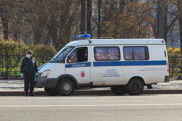 Saint-Petersburg, Russia - May 1 2020: Traffic policeman controls the traffic in the city center. A fat masked policeman stands on the road and looks away