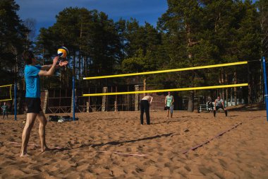 Saint Petersburg, Rusya - 5 Mayıs 2020: Sahilde plaj voleybolu oynayan sıradan insanlar. Şehrin, koronavirüs salgınıyla bağlantılı bir kendini izole etme rejimi var.