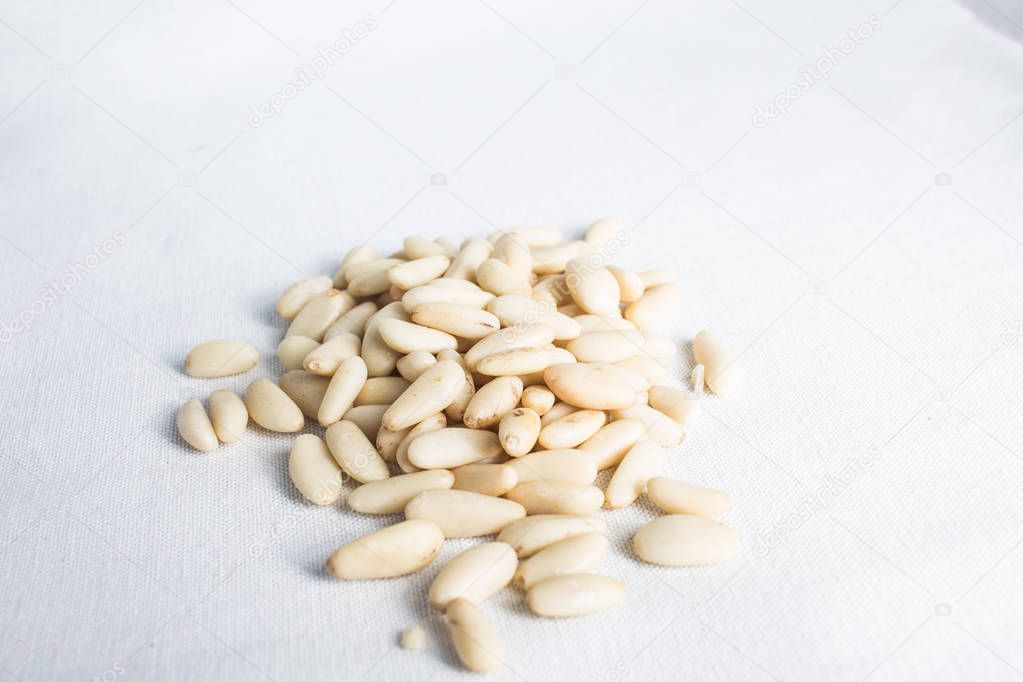 peeled pine nuts on white background