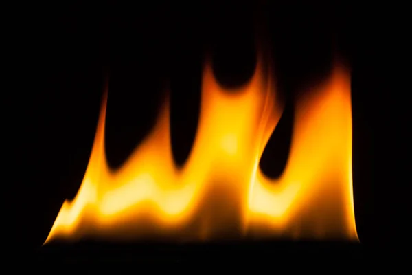 Огненное пламя, зажженное на черной земле — стоковое фото