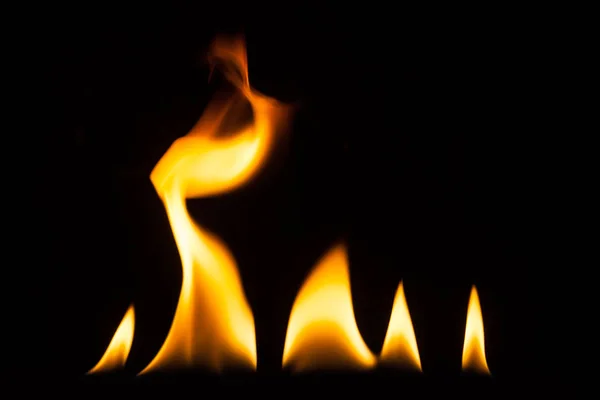 Chama de fogo isolado em solo preto — Fotografia de Stock