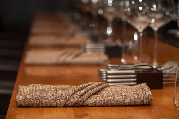 Gefaltete Serviette auf dem Holztisch im Restaurant — Stockfoto